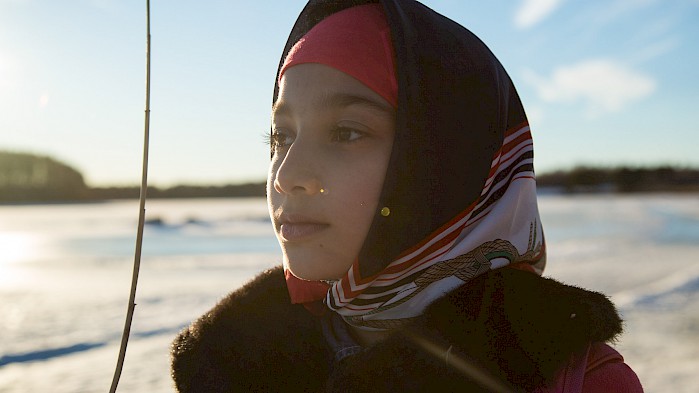 Sahar looks out over a frozen lake in Sweden.