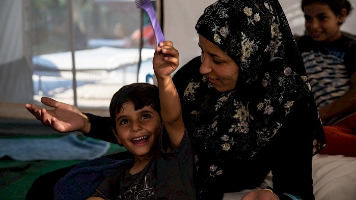Zahra and her son enjoy a happy moment in a refugee camp in Greece.